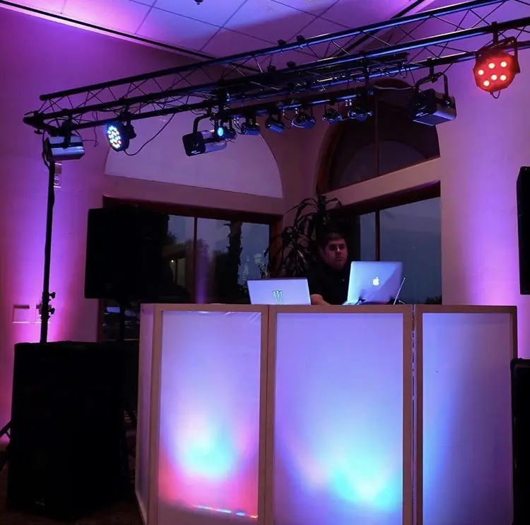 Professional DJ booth and overhead lighting truss at an indoor event